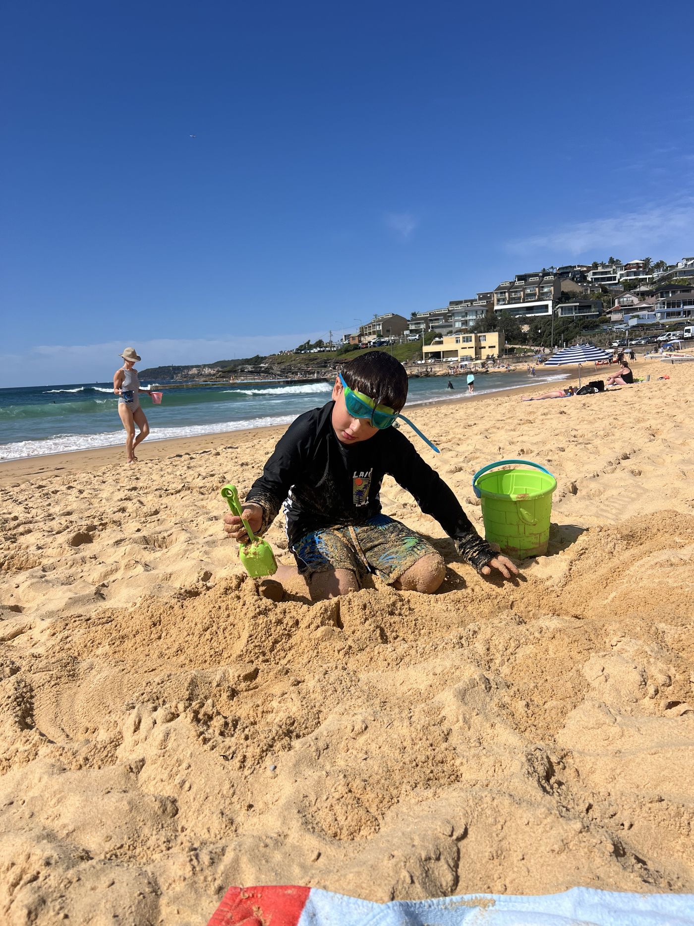 A young person building sandcastles at the beach